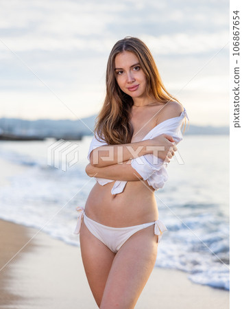 Beautiful woman with blond hair in elegant bikini posing on sunset beach Beautiful woman with blond hair in elegant bikini posing on sunset beach 106867654