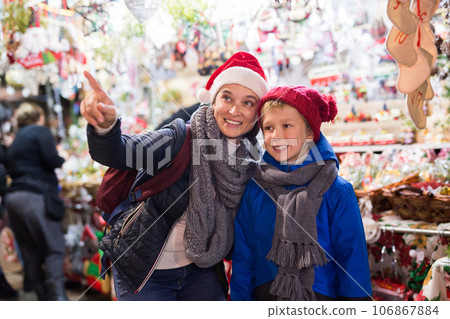 Preteen boy having fun at Christmas fair with mother 106867884