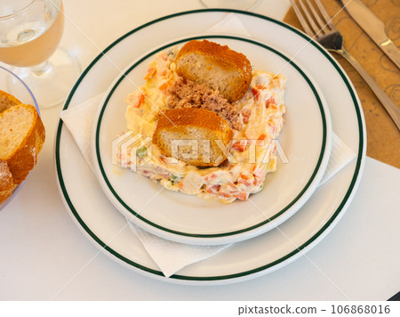 Olivier salad with minced canned tuna and crispy toasts 106868016