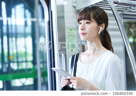 Young woman riding a train. Photography provided by Keio Electric Railway Co., Ltd. 106868390