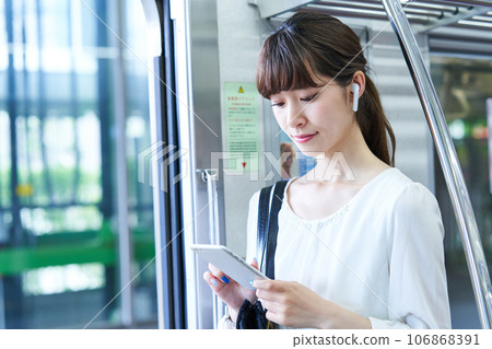 Young woman riding a train. Photography provided by Keio Electric Railway Co., Ltd. 106868391