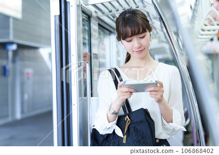 Young woman riding a train. Photography provided by Keio Electric Railway Co., Ltd. 106868402