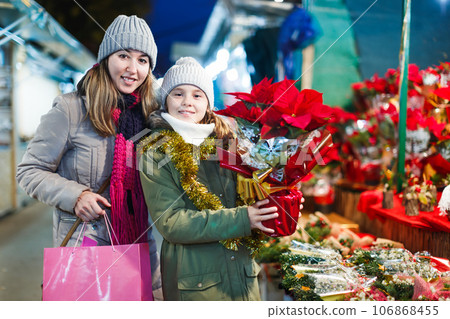 Girl with woman choosing Christmas gifts for family 106868455