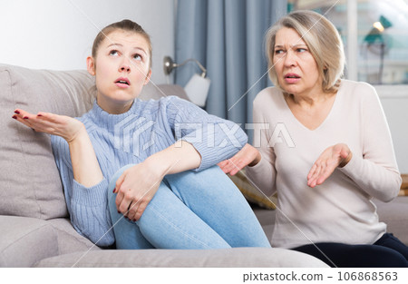 Mature mother and adult daughter scandal in domestic interior 106868563