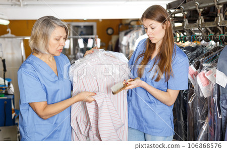 Two female dry-cleaning salon employees Two female dry-cleaning salon employees 106868576