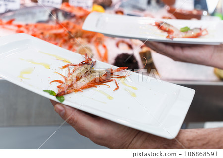 Grilled langoustine on dish in hand of waiter Grilled langoustine on dish in hand of waiter 106868591
