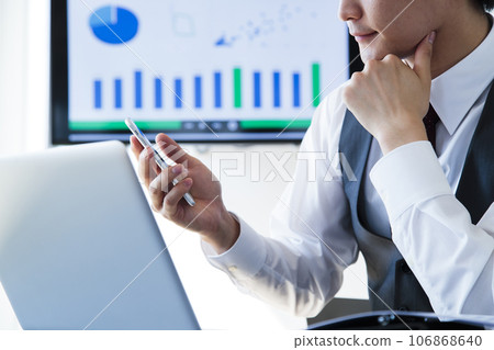 A young businessman working on a smartphone and computer in the office 106868640