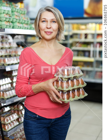 woman shopping for eggs in food department woman shopping for eggs in food department 106868705