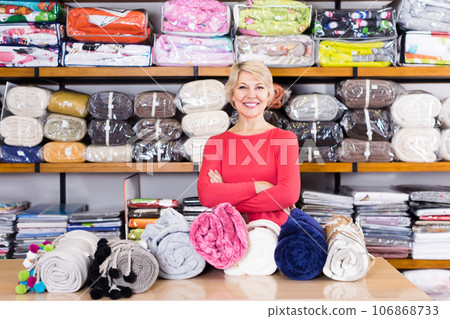 senior seller showing wide assortment of home textiles senior seller showing wide assortment of home textiles 106868733