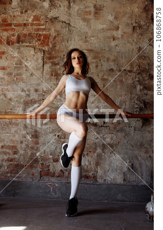 Beautiful sportswoman on the background of a brick wall Beautiful sportswoman on the background of a brick wall 106868758