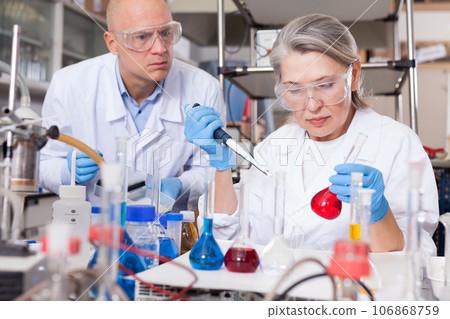 Scientists mixing reagents Scientists mixing reagents 106868759