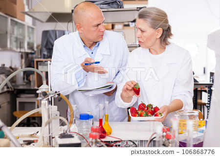 Scientists taking notes while performing experiments 106868776