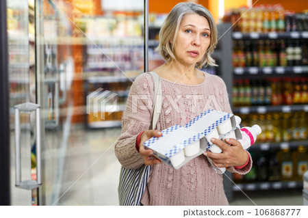 Mature woman choosing dairy products 106868777