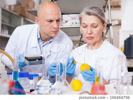 Biochemists injecting chemicals into lemon Biochemists injecting chemicals into lemon 106868796