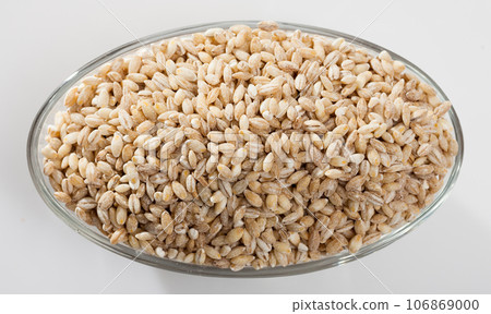 Barley groats in glass bowl on white surface , nobody Barley groats in glass bowl on white surface , nobody 106869000