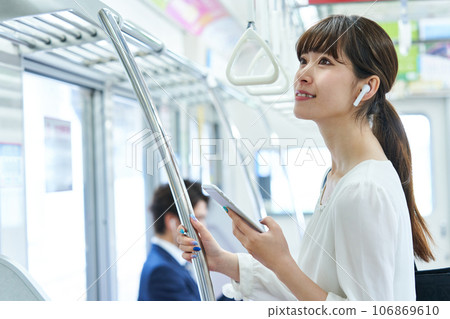 Young woman riding a train. Photography provided by Keio Electric Railway Co., Ltd. Young woman riding a train. Photography provided by Keio Electric Railway Co., Ltd. 106869610