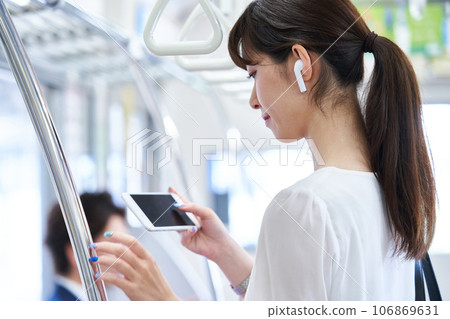 Young woman riding a train. Photography provided by Keio Electric Railway Co., Ltd. Young woman riding a train. Photography provided by Keio Electric Railway Co., Ltd. 106869631