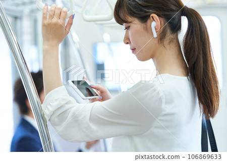 Young woman riding a train. Photography provided by Keio Electric Railway Co., Ltd. 106869633