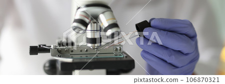 Scientist works with pipette and microscope in research laboratory. Scientist works with pipette and microscope in research laboratory. 106870321