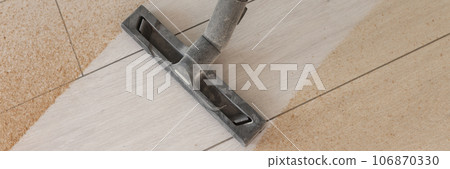 Vacuum cleaner made clean strip on the dusty wooden floor 106870330