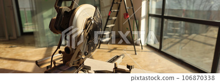 Electric circular saw on stand and wooden board close up. 106870338