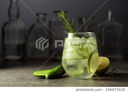 Cocktail gin tonic with ice, rosemary, lime, and cucumber. 106872816