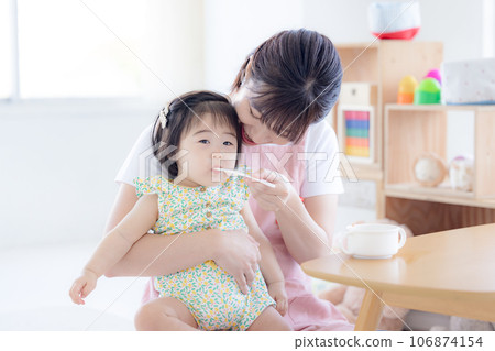 Baby and childcare worker eating baby food 106874154