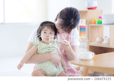 Baby and childcare worker eating baby food 106874155