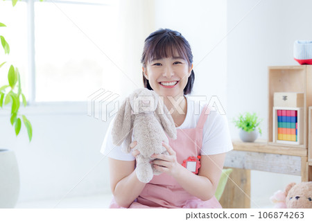 Nursery teacher portrait A nursery teacher holding a stuffed animal and smiling looking at the camera Nursery teacher portrait A nursery teacher holding a stuffed animal and smiling looking at the camera 106874263