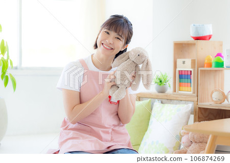 Nursery teacher portrait A nursery teacher holding a stuffed animal and smiling looking at the camera Nursery teacher portrait A nursery teacher holding a stuffed animal and smiling looking at the camera 106874269