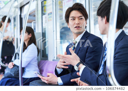 A man talking on a train. Photography provided by Keio Electric Railway Co., Ltd. 106874482