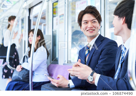 A man talking on a train. Photography provided by Keio Electric Railway Co., Ltd. A man talking on a train. Photography provided by Keio Electric Railway Co., Ltd. 106874490