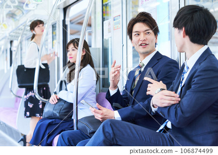 A man talking on a train. Photography provided by Keio Electric Railway Co., Ltd. 106874499