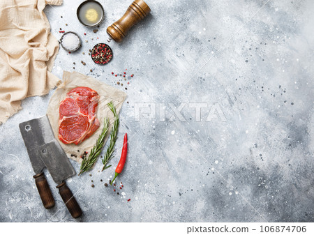 Raw beef rib eye steak on with meat cleaver on light kitchen table background with salt 106874706