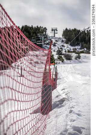 Detail of orange plastic barrier on ski slope Detail of orange plastic barrier on ski slope 106874944