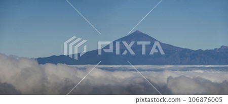Panoramic aerial view of volcano Pico del Teide and Tenerife island above white clouds seen from La Gomera, Canary Islands, Spain, Europe. Panoramic aerial view of volcano Pico del Teide and Tenerife island above white clouds seen from La Gomera, Canary Islands, Spain, Europe. 106876005