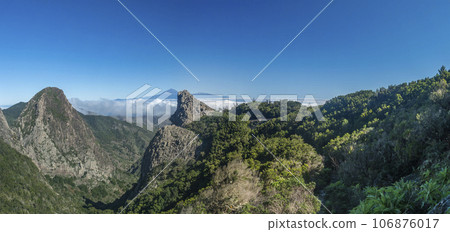 Panoramic scenic view from the Mirador del Bailadero with volcanic rock formations Los Roques and island Tenerife and Volcano Pico de Teide. Garajonay National Park on La Gomera, Canary Islands, Spain 106876017