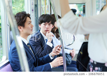 A man talking on a train. Photography provided by Keio Electric Railway Co., Ltd. A man talking on a train. Photography provided by Keio Electric Railway Co., Ltd. 106876051