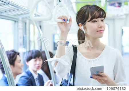 Young woman riding a train. Photography provided by Keio Electric Railway Co., Ltd. 106876182