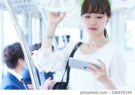 Young woman riding a train. Photography provided by Keio Electric Railway Co., Ltd. 106876194