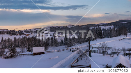 Pre-dawn alpine small quiet village and winter snowy mountains around panorama view. 106877080