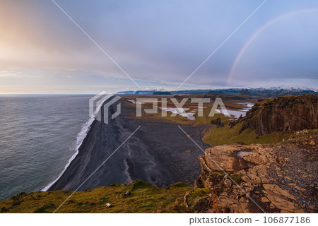 Picturesque autumn evening view to endless ocean black volcanic sand beach from Dyrholaey Cape Viewpoint, Vik, South Iceland. Picturesque autumn evening view to endless ocean black volcanic sand beach from Dyrholaey Cape Viewpoint, Vik, South Iceland. 106877186