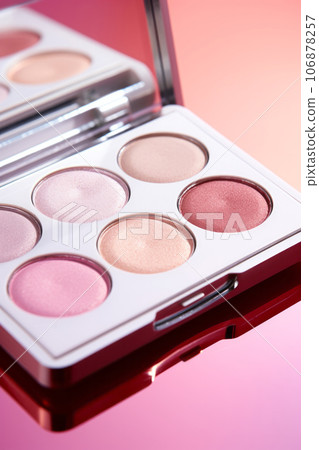 A close-up of pearlescent shimmery palette of pink eyeshadows for creating eye makeup 106878257