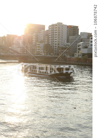 沐浴著夕陽的水上巴士沿著河邊行駛 沐浴著夕陽的水上巴士沿著河邊行駛 106878742