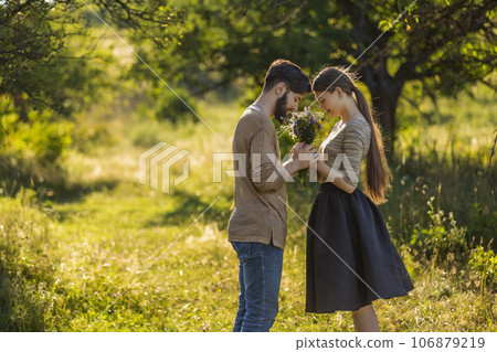 couple in nature with wildflowers 106879219
