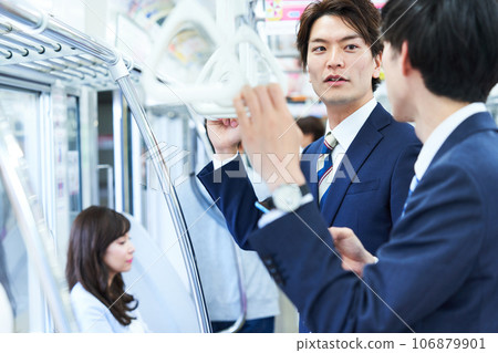 A man talking on a train. Photography provided by Keio Electric Railway Co., Ltd. A man talking on a train. Photography provided by Keio Electric Railway Co., Ltd. 106879901