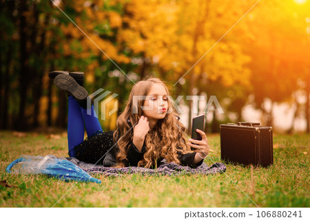 Cute stylish girl with long blonde hair in autumn park. Autumn kids fashion, lifestyle portrait. Cute stylish girl with long blonde hair in autumn park. Autumn kids fashion, lifestyle portrait. 106880241