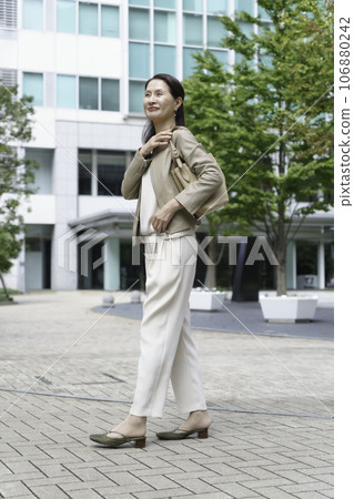 Fashion portrait of a senior woman commuting, vertical position 106880242