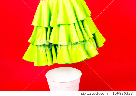 Shot of a young woman hand throwing her outwear dress in the trash isolated on red background Shot of a young woman hand throwing her outwear dress in the trash isolated on red background 106880338