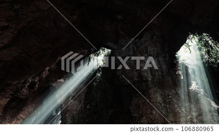 Sunlight streaming into a mysterious cave, creating a volume of light Sunlight streaming into a mysterious cave, creating a volume of light 106880965